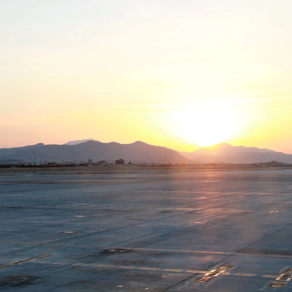 Amanecer sobre la pista del aeropuerto de Barcelona vista desde la terminal, composición editorial